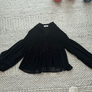 Smocked top with balloon sleeves. Loose material. Button closure front.